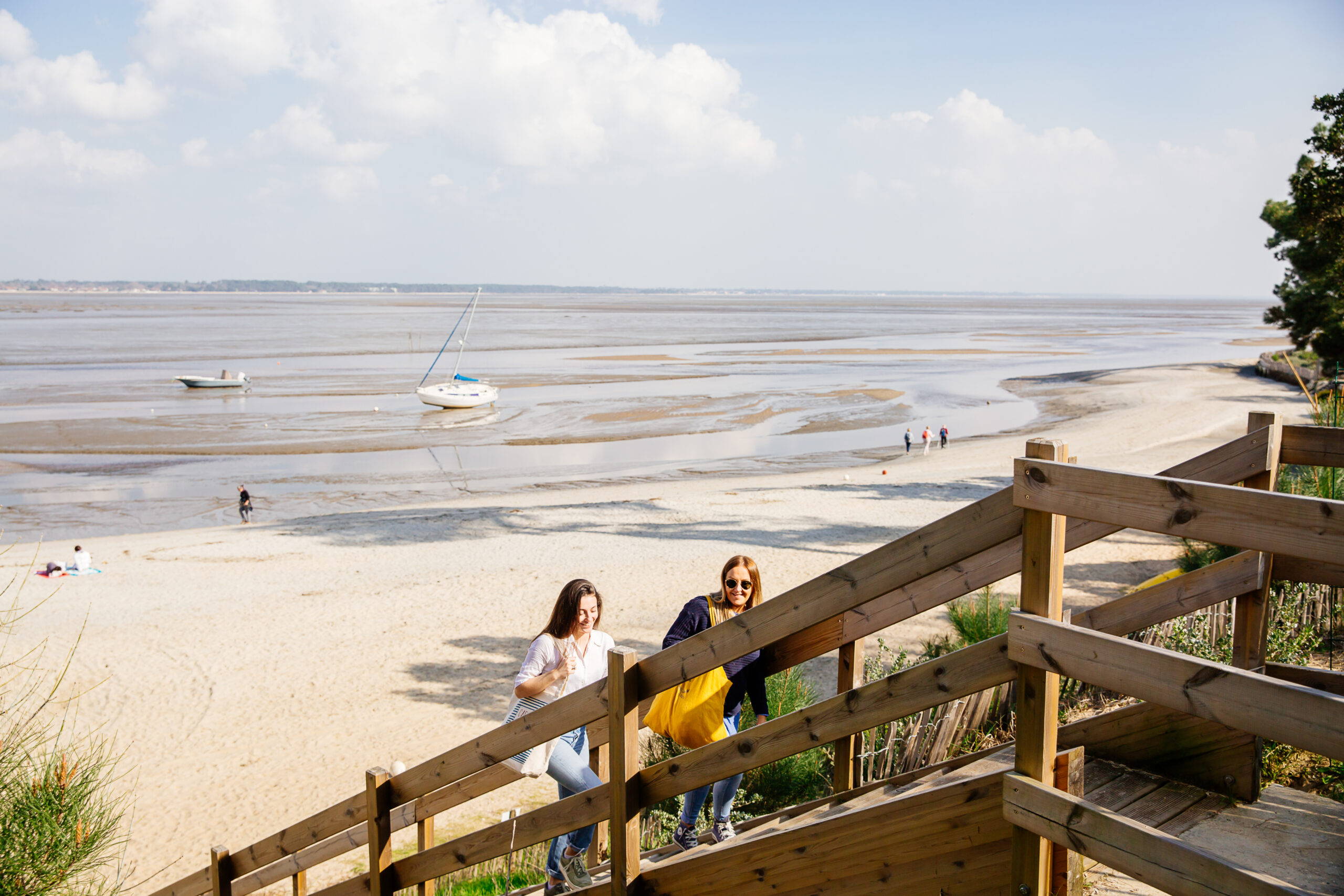Des femmes montent l'escalier qui permet de relier le camping les pastourelles de la plage à Claouey. 
