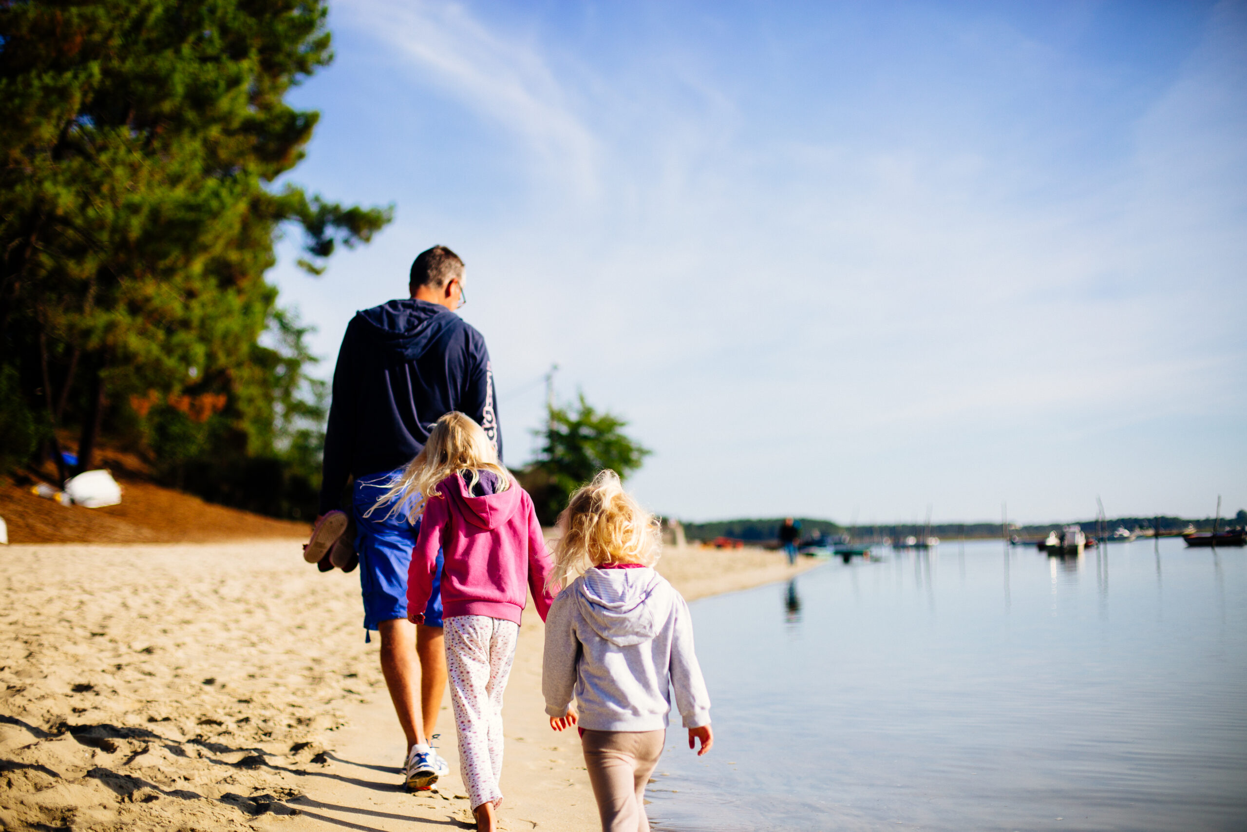 Une famille se promène en fin de journée sur la plage au bord de l'eau à Claouey.