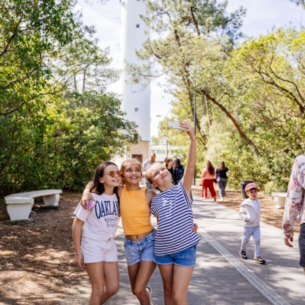 Des enfants se prennent en photo à l'entrée du phare du cap ferret.