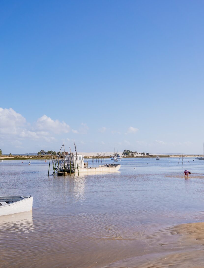 Vue sur la plage du Mimbeau avec le bassin et les bateaux de pêche.