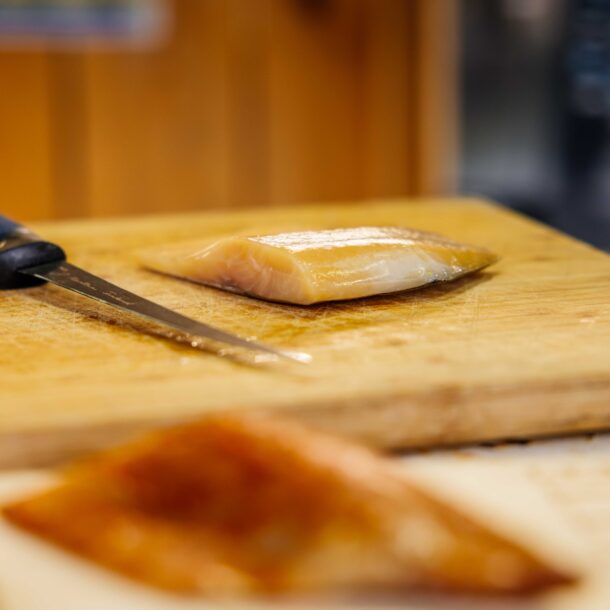 Un poisson fumée sur un planche avec un couteau à côté.