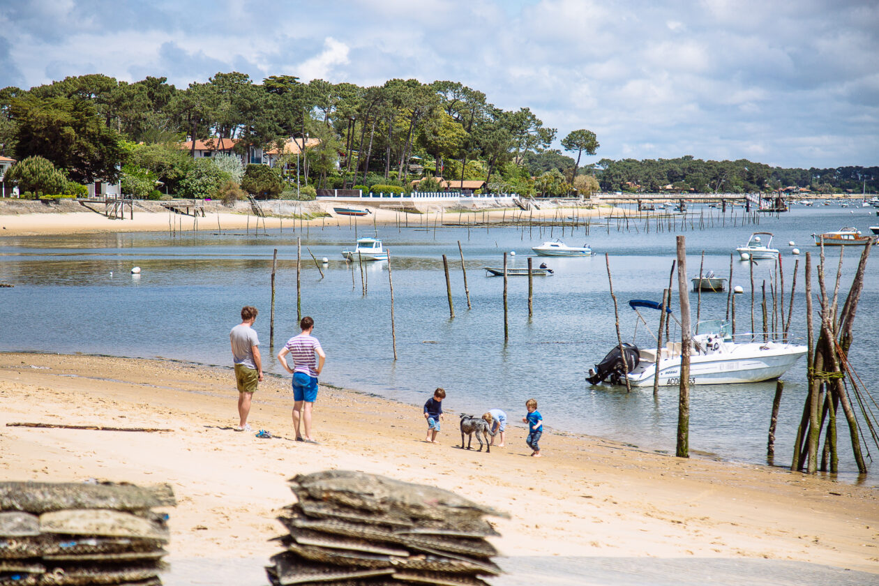 Vue imprenable du restaurant sur la plage, où des enfants jouent sous le regard attentif de leurs parents.