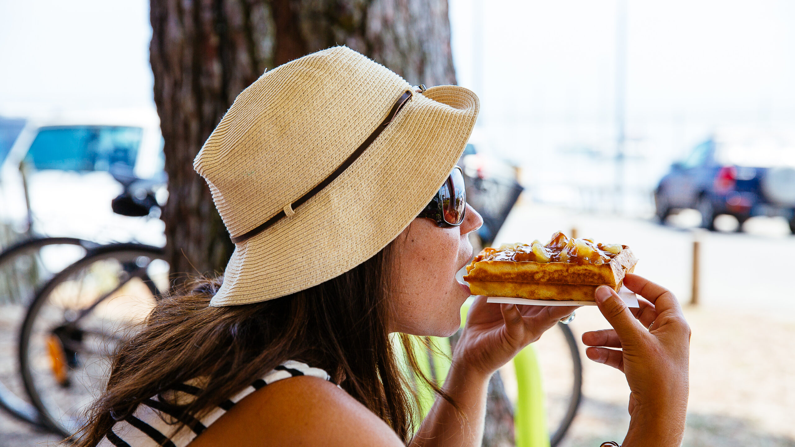 Femme dégustant une gaufre sur le port de Claouey à Lège-Cap Ferret