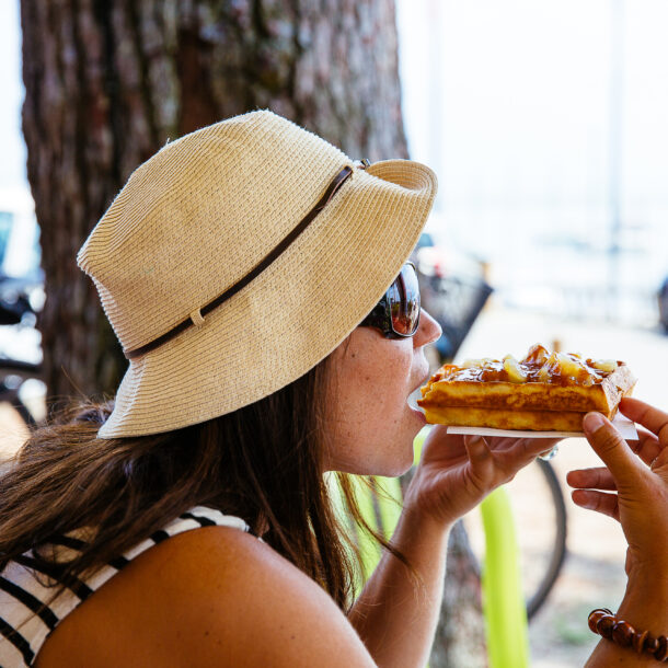 Femme dégustant une gaufre sur le port de Claouey à Lège-Cap Ferret